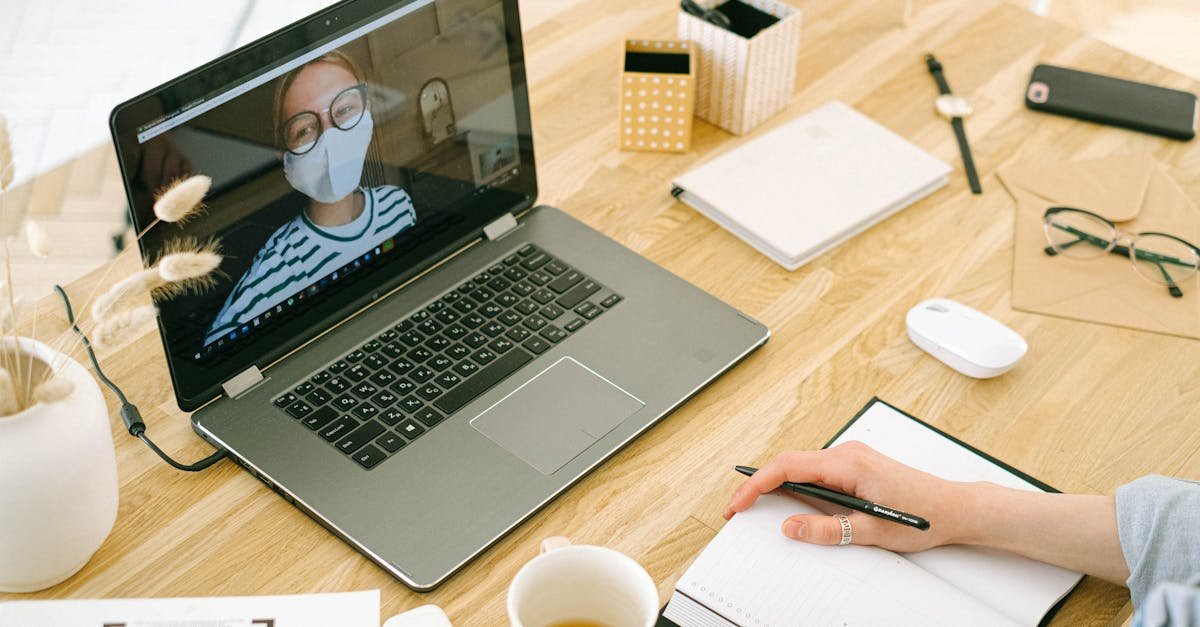 A laptop and notepad set up for a telehealth that takes insurance video appointment