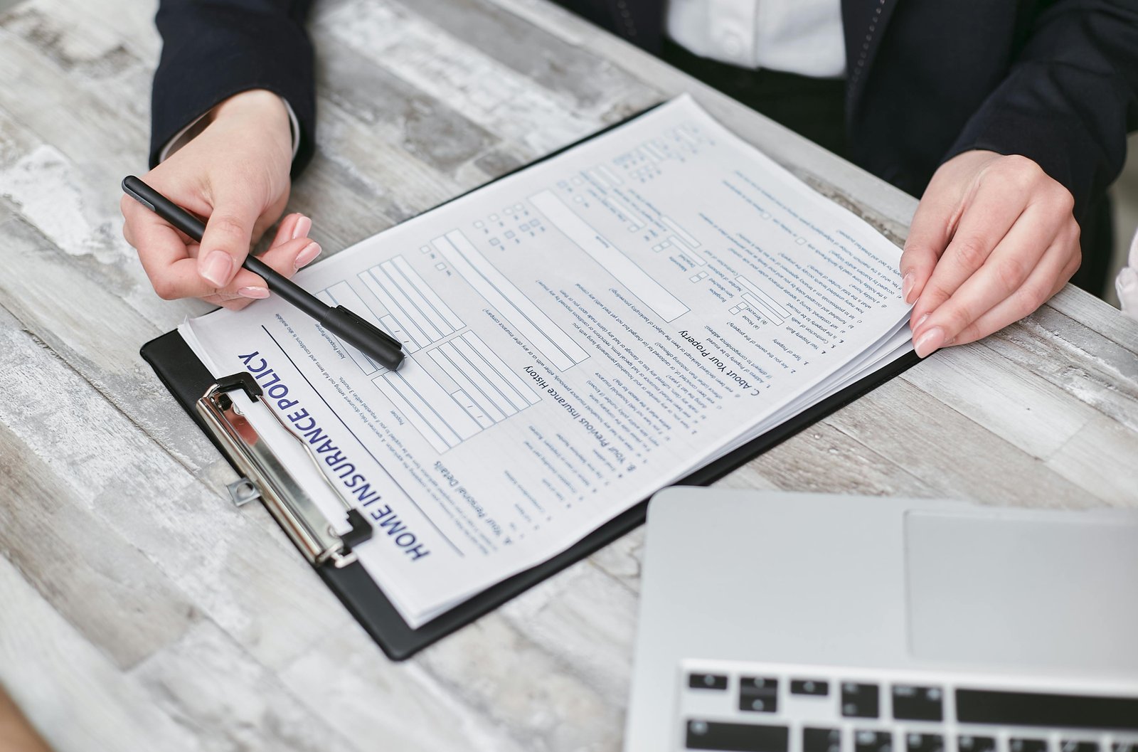 A person comparing insurance documents and a calculator while planning for care costs