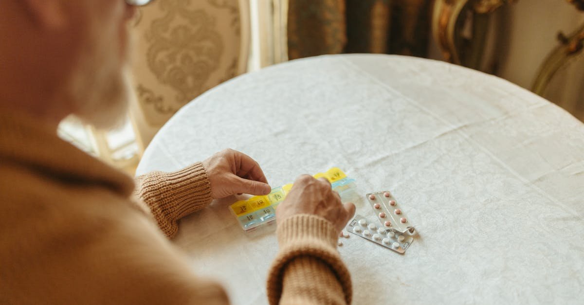 A person organizing medications while researching how to lower prescription costs